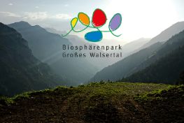Logo des Biosphärenpark auf einem Bild vom Tal